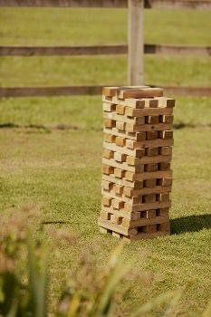 a large wooden block sitting in the middle of a field next to a horse fence