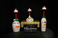 three snowmen with candles on top of them and a sign that says all you need is christmas