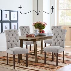 a dining room table and chairs with a rug on the floor in front of it