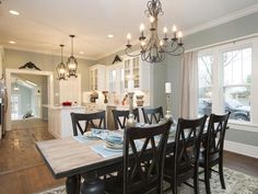 a dinning room table and chairs in front of a large window with lots of windows