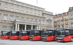 four buses are parked in front of a building