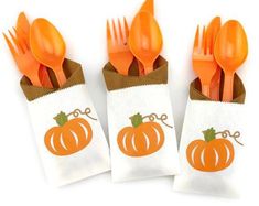 orange plastic forks and spoons in a paper bag with a pumpkin design on it