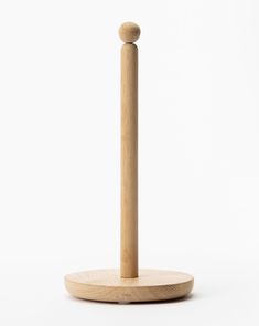 a wooden object on a white surface with a stick sticking out of it's center