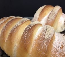 several loaves of bread sitting on top of a cooling rack with powdered sugar