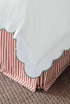 a bed with red and white striped sheets