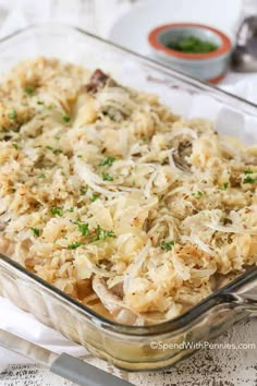 a casserole dish filled with rice and mushrooms, garnished with parsley