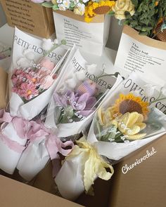 flowers are wrapped in white paper and tied with pink ribbon on top of the boxes