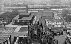 black and white photograph of an old building in the middle of a city with tall buildings