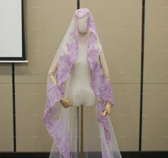 a mannequin wearing a purple veil and headpiece