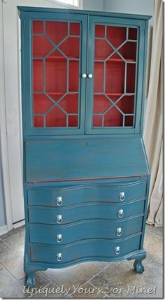 an old dresser painted blue with red glass doors