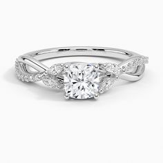 a white gold engagement ring with an oval cut diamond and two round diamonds on the band