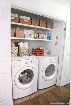 a washer and dryer sitting in a room next to each other with baskets on the shelves