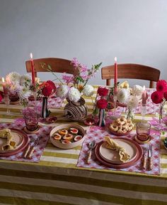 the table is set with plates, cups and flowers