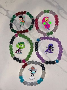 six bracelets with cartoon characters on them sitting on a counter top next to each other