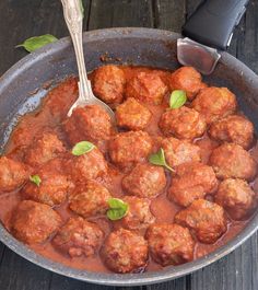 meatballs and sauce in a pan on a wooden table