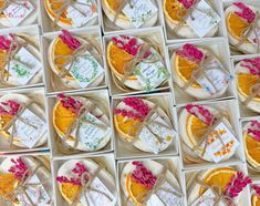 many orange slices are arranged in boxes with writing on them and tied to strings around the edges