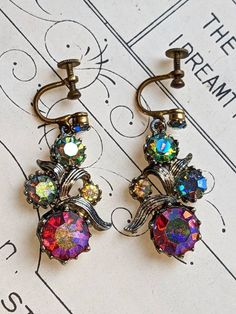 Here we have a beautiful 1940's pair of Delissa Juliana Screw back earrings, featuring stunning aurora borealis rainbow Crystals. The screw backs seem to be in an aged gold toned metal and the backs of the earrings in a silver toned metal. There seems to be a slight patina and tarnish to them, however they are still absolutely beautiful.  Why not give the gift of history... Like a time capsule as a gift. ~FREE DELIVERY~ If you have any questions, queries, or want to know more about shipping else Victorian Clip-on Drop Earrings, Victorian Style Clip-on Drop Earrings, Vintage Nickel-free Clip-on Earrings For Wedding, Nickel-free Retro Formal Earrings, Nickel-free Retro Earrings For Formal Occasions, Nickel Free Retro Formal Earrings, Nickel Free Vintage Clip-on Earrings For Wedding, Nickel Free Retro Earrings For Formal Occasions, Antique Clip-on Earrings For Vintage Events