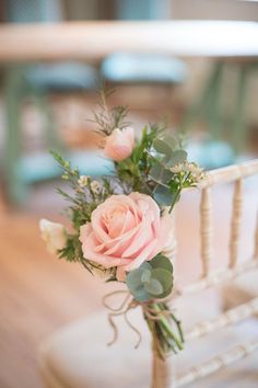 a bouquet of pink roses sitting on top of a white chair next to a table