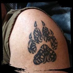 a man with a tattoo on his arm that has a dog's paw in it