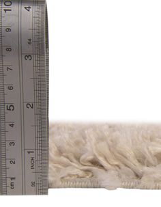 a measuring tape is next to a pile of wool