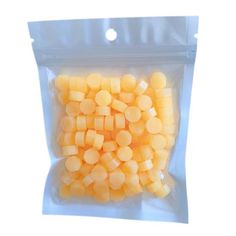 a bag filled with yellow dices on top of a white surface