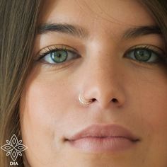 a woman with piercings on her nose looking at the camera