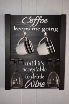 two wine glasses hanging on a wall with a sign that says coffee keeps me going until it's accessible to drink wine