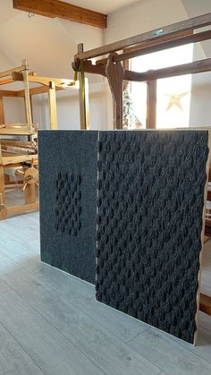 two black tiles sitting on top of a hard wood floor next to chairs and ladders