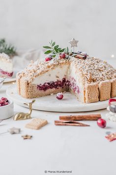 a cake is cut into pieces on a white plate with christmas decorations around the edges