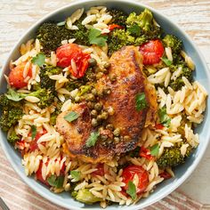 a blue bowl filled with rice, meat and veggies on top of a wooden table