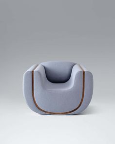 a blue chair with a brown leather trim on the seat and back, in front of a gray background