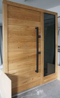 a large wooden door with glass panels and black handles on the outside of a building