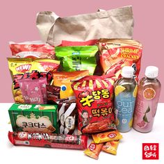 a bag full of snacks and drinks sitting next to each other on a white table