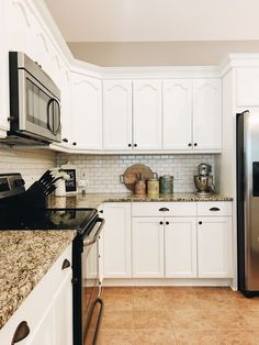 a kitchen with white cabinets and granite counter tops