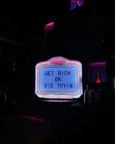 a neon sign that says get rich or die tryin'on it in the dark