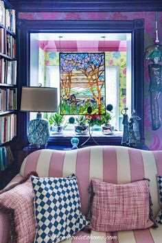 a living room filled with lots of furniture and bookshelves covered in colorful wallpaper