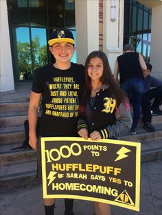 two people standing next to each other holding a sign that says 100 points to hufflepuff if saran says yes to home coming