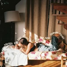 a woman laying on top of a bed next to a wooden stair case in a room