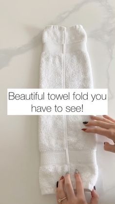 a woman holding a white towel with the words beautiful towel fold you have to see