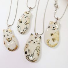 three necklaces with cats on them sitting next to each other