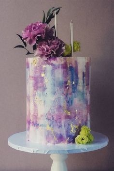 there is a cake with flowers on the top and purple icing in the middle