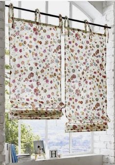 two windows with floral curtains hanging from them