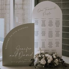 a table plan sitting on top of a window sill next to a bouquet of flowers