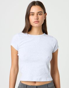 This top is a neccessary basic with a crew neckline and fitted baby tee style. Trendy Crew Neck Top For Layering, Basic Everyday Fitted T-shirt, Everyday Fitted Basic T-shirt, Trendy Short Sleeve Crew Neck Top For Layering, Everyday Stretch Crew Neck Tops, Gray Cotton Top With Ribbed Neckline, Basic Fitted Cropped T-shirt With Crew Neck, Basic Stretch Tops With Ribbed Neckline, Basic Top With Ribbed Neckline