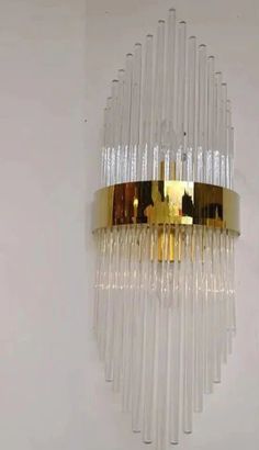 a gold and clear chandelier hanging from the ceiling in a white walled room