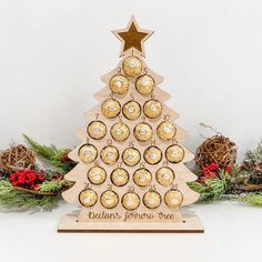 a wooden christmas tree with chocolates in it