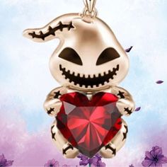 a silver pendant with a red heart in the shape of a skeleton holding a jack - o - lantern