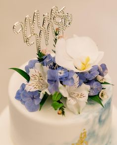 a close up of a cake with flowers on it and the word happy spelled out