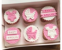 baby shower cupcakes in a box with pink and white icing on them