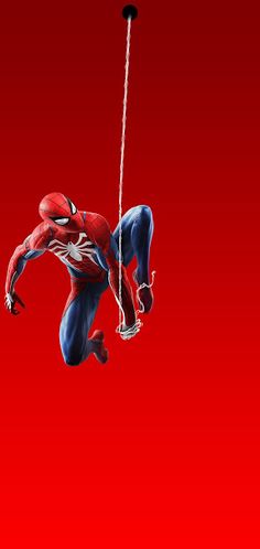 a spider - man swinging on a rope in the air with his legs spread out